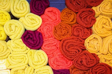 View on stack of rolled cloths in different colors on French market - Provence, France