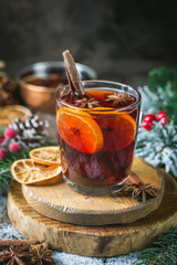 Christmas mulled red wine with spices and fruits on a wooden rustic table. Traditional hot drink at...