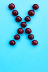 Letter X fresh cherry alphabet blue color flat lay