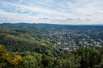 View over the green city on a sunny cloudy fall day with green and yellow trees and clouds