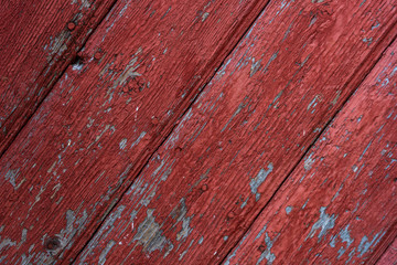 Pattern of an old red wooden door and texture closeup of chipped and cracked paint. Minimalist and diagonal lines background.