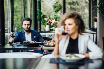 Focus at handsome bearded man looking at beautiful woman befire him.