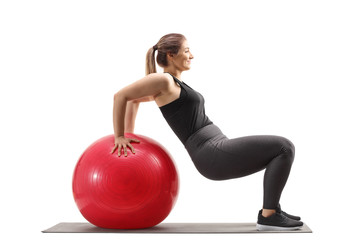 Young woman exercising sit ups with a fitness ball