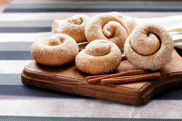 Snail sugar cookies with cinnamon on wooden board