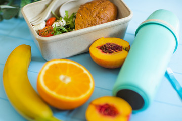 Lunch box with sandwich, vegetables, banana, water, nuts and oranges. Fresh eat.