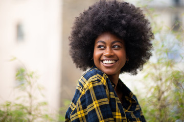 horizontal portrait of young black woman with afro hair smiling