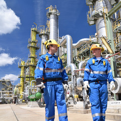 Industriearbeiter in Erdölraffinerie // chemical industry plant - workers in work clothes in a...