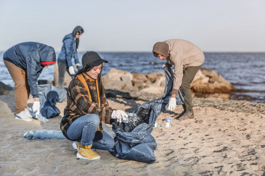 Team of young volunteers are picking up plastic on a beach