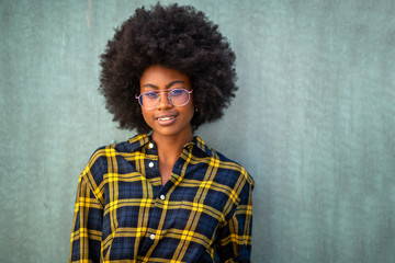 Close up front young afro woman with glasses smiling against green background