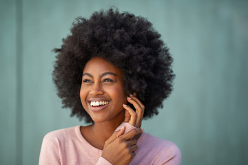 Close up young african american woman with afro smiling and hand on face