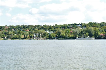 A pond on the banks of which is a small town with a lot of trees.