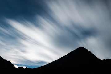 Silhouette of Mount Emilius with fast clouds passing in the sky