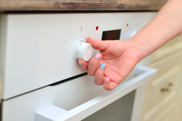 The girl chooses the mode of the oven