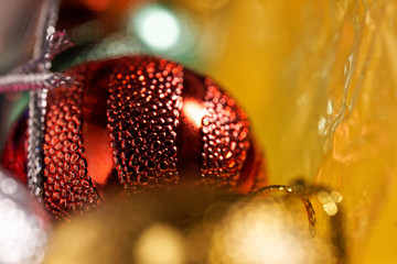 Christmas toys in a box for decorations. Close-up. Red ball on a golden yellow background. Preparing for the New Year holidays. Macro. Bokeh and shallow depth of field