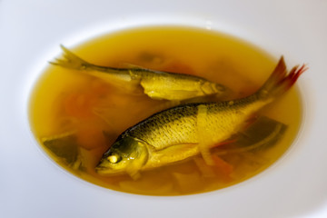 Fish boiling soup with vegetables. Healthy food  with carrot, pepper, herbs and potato 