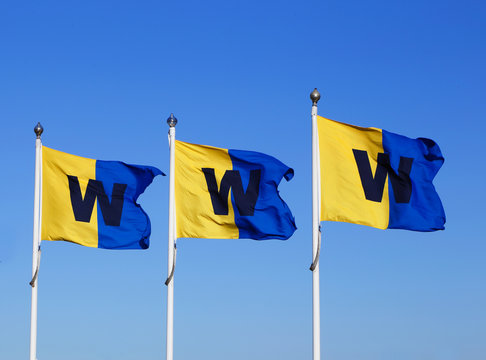 Stockholm, Sweden - April 22, 2014: The Stockholm archipelago boat service company Waxholmsbolaget flags against a blue sky at Sluusen in Stockholm.