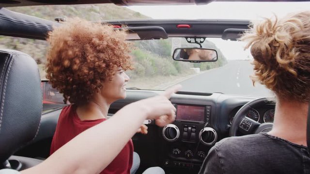 Group Of Young Friends Driving Open Top Hire Car On Summer Vacation