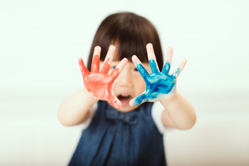 toddler girl show her hands with paint