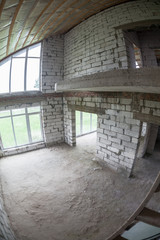 Second-level space with high windows from floor to ceiling, gas concrete block unfinished house