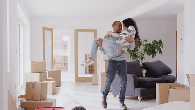 Man Carrying Woman Over Threshold Of New Home On Moving Day
