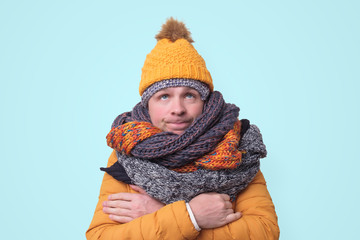 Handsome caucasian funny man in several hats and scarfs.