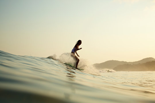 Female surfer riding ocean wave