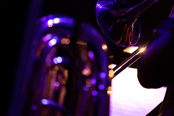 A trombonist of a big band trombone section during a performance with a streak of light from the...