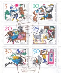 A block of postage stamps from Germany which depicts a German folk tale about a magic table, a donkey and a truncheon