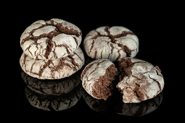 Group of three whole two halves of baked chocolate brownie cookie isolated on black glass