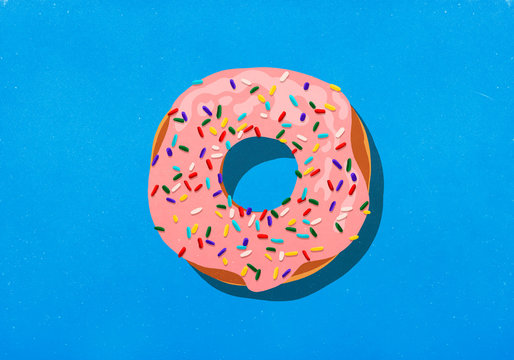 Pink donut with sprinkles on blue background