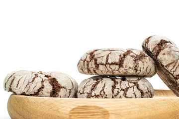 Group of four whole baked chocolate brownie cookie on bamboo plate isolated on white background