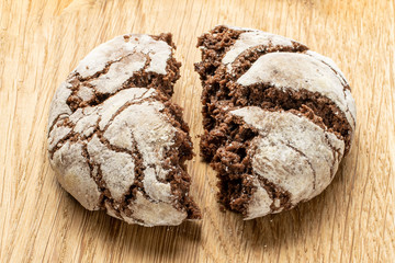 Group of two halves of baked chocolate brownie cookie on natural wood