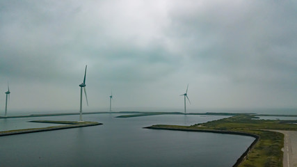 Aerial view of several wind turbines in Holland on the Oosterschelde. Misty and overcast weather.
