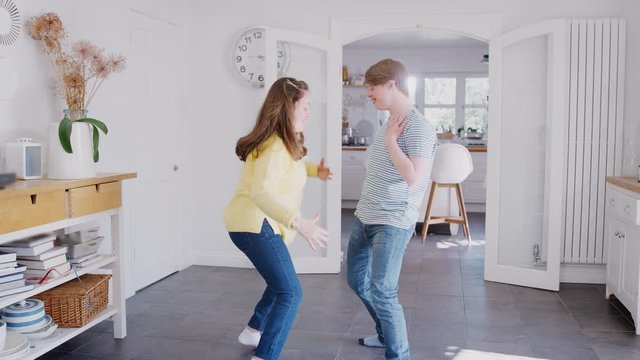 Young Downs Syndrome Couple Having Fun Dancing At Home Together