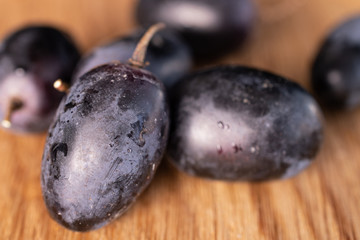 Lot of whole fresh black grape on natural wood