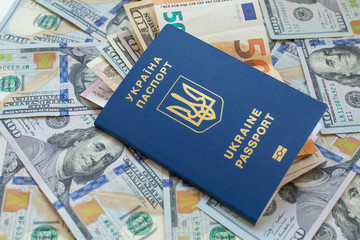 Fototapeta premium New biometric Ukrainian passport with electronic chip id.Free travel to Europe without visa.Close up shot of travellers document with paper US dollar currency