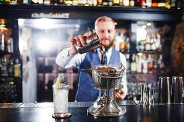 Cocktail at bar. Expert Bartender is making alcoholic cocktail.