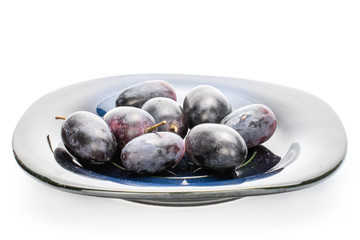 Lot of whole fresh black grape on grey plate isolated on white background