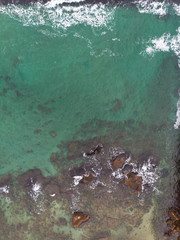 Aerial view of the seashore. Waves, stones and sandy shore.