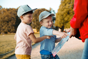 Brothers travelers. Kids in front of a map. Adventure and travel concept.