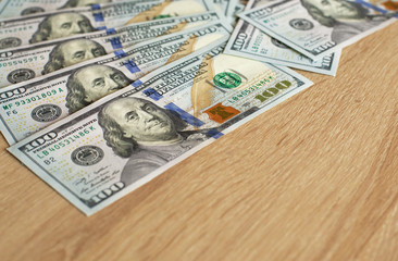US dollars on a wooden background. close up view of cash money dollars bills in amount. usiness, finance, saving, banking, travel and people concept - close up.