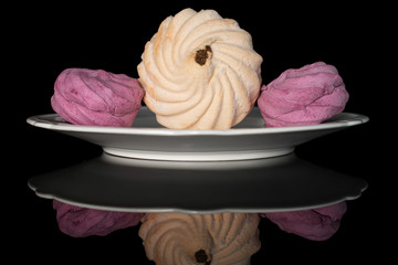Group of three whole fresh pastel zefir on white plate isolated on black glass