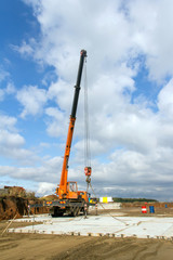 Construction crane on a wheelbase at a construction site. Unloading work.