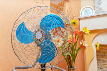 Closeup on electric floor standing fan at modern home in sunny hot summer day.