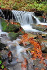 Fototapeta na wymiar Mountain waterfall in autumn forest