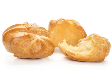 Group of one whole two halves of baked golden profiterole one teared isolated on white background