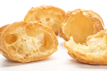 Group of four halves of baked golden profiterole isolated on white background