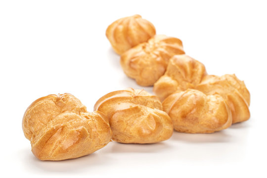 Group of seven whole baked golden profiterole triangle isolated on white background