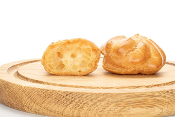 Group of one whole one half of baked golden profiterole on bamboo plate isolated on white background