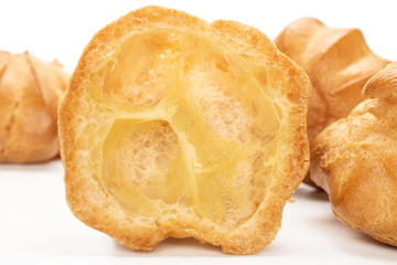 Lot of whole one half of baked golden profiterole cross section isolated on white background